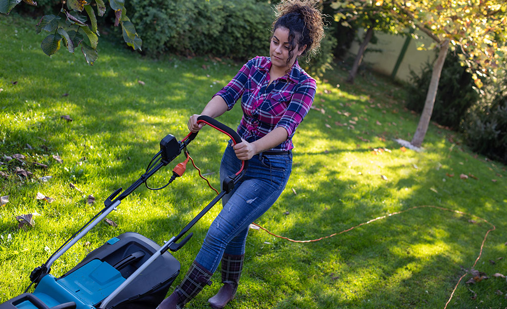 A woman mowing a lawn.