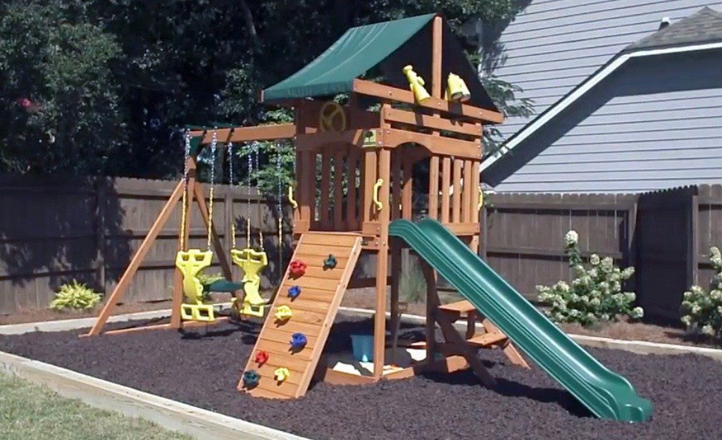 A completed swing set in a backyard.