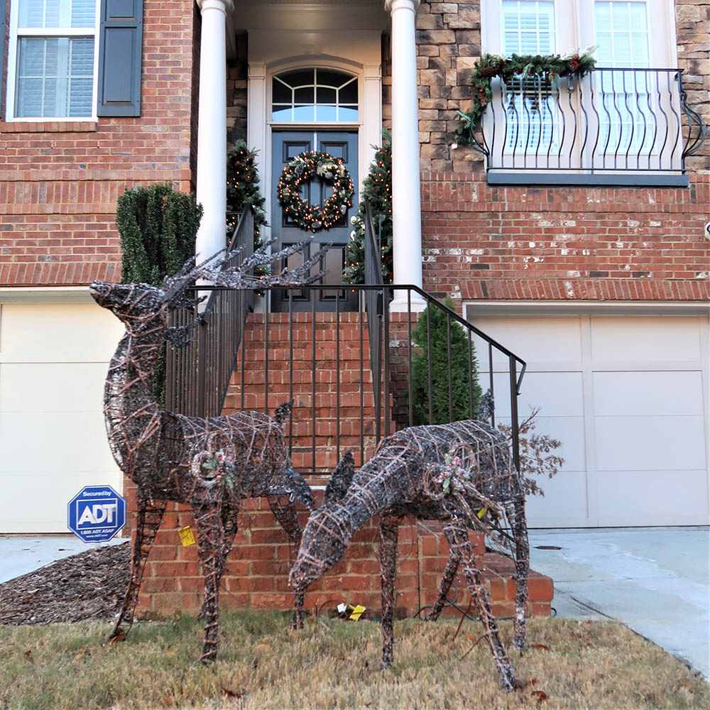 A pair of LED deer decorate the front yard of a townhouse.