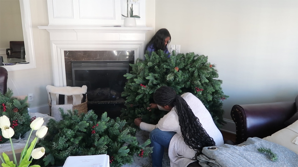 Two women put together an artificial Christmas tree.