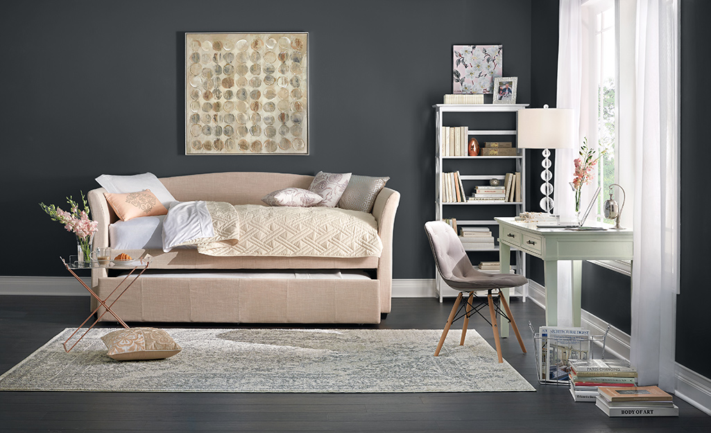 A room with white shoe moulding on a dark gray wall.