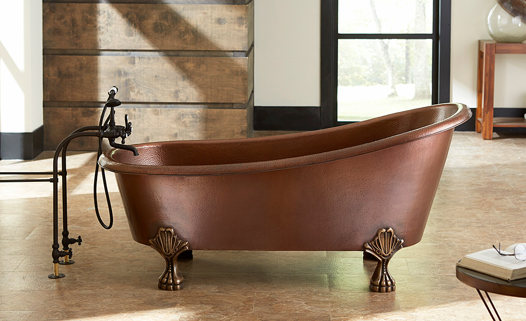 A freestanding copper clawfoot bathtub in a contemporary bathroom.