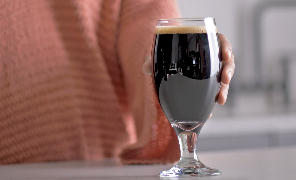 A stout glass on a table filled with beer.