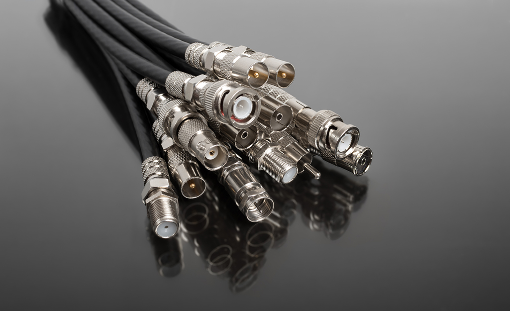 Several different coaxial cable connectors stacked together.
