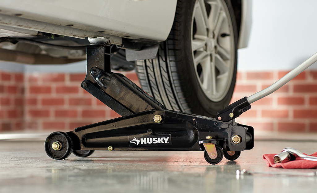 A closeup of a car situated on a floor jack