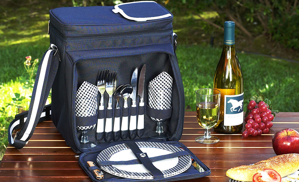 A blue cooler holds plates, glasses and flatware in a separate zipped pouch.