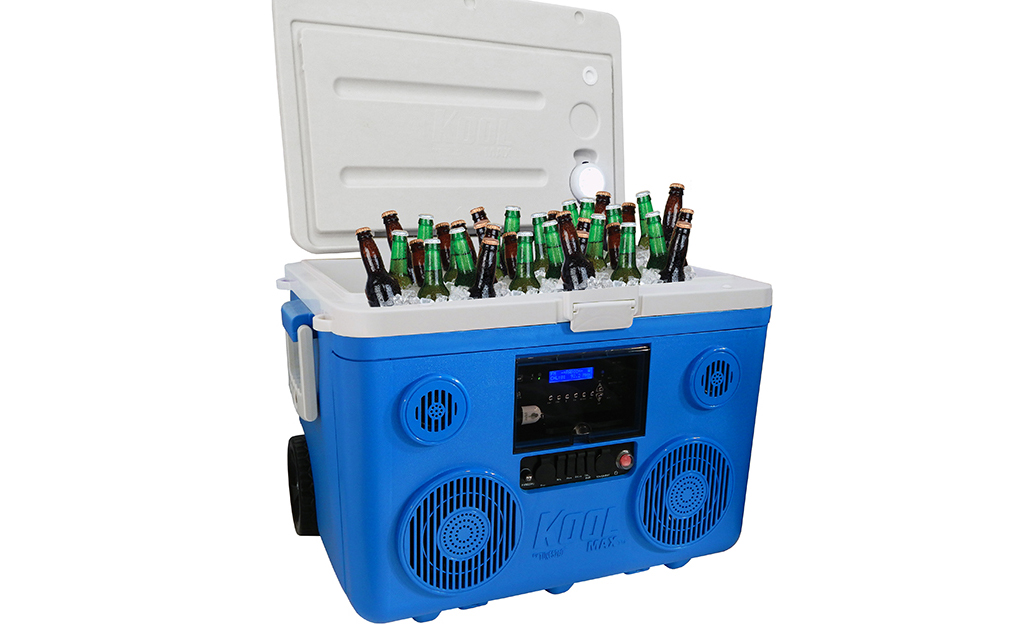 A blue cooler with speakers is filled with ice and bottled beverages.