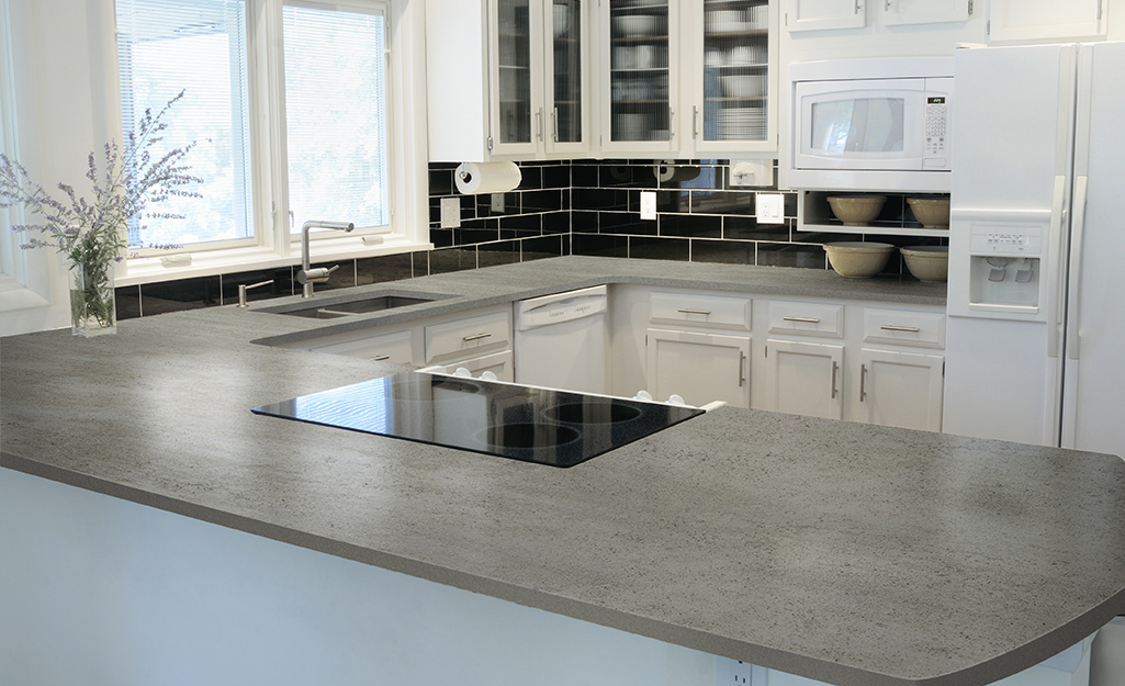 A concrete slab countertop in a white kitchen.