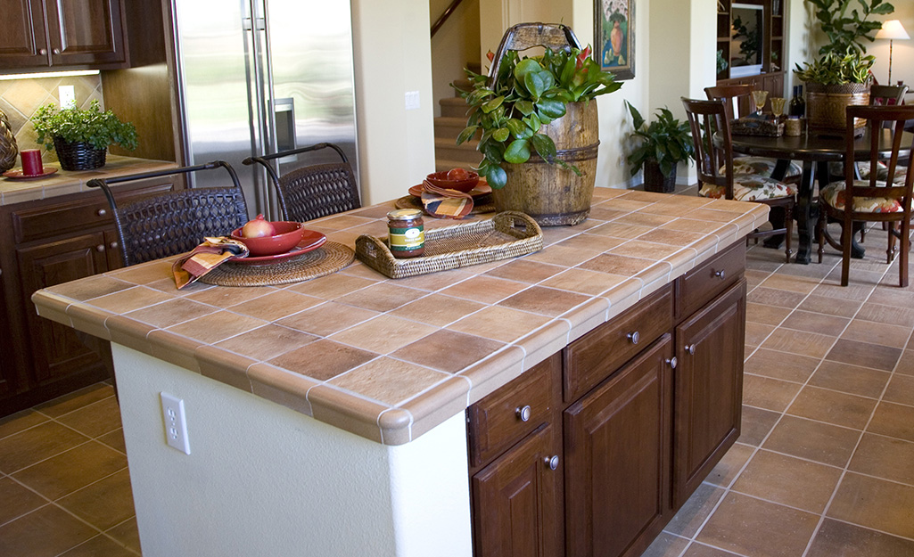 A ceramic tile countertop island in a neutral kitchen.