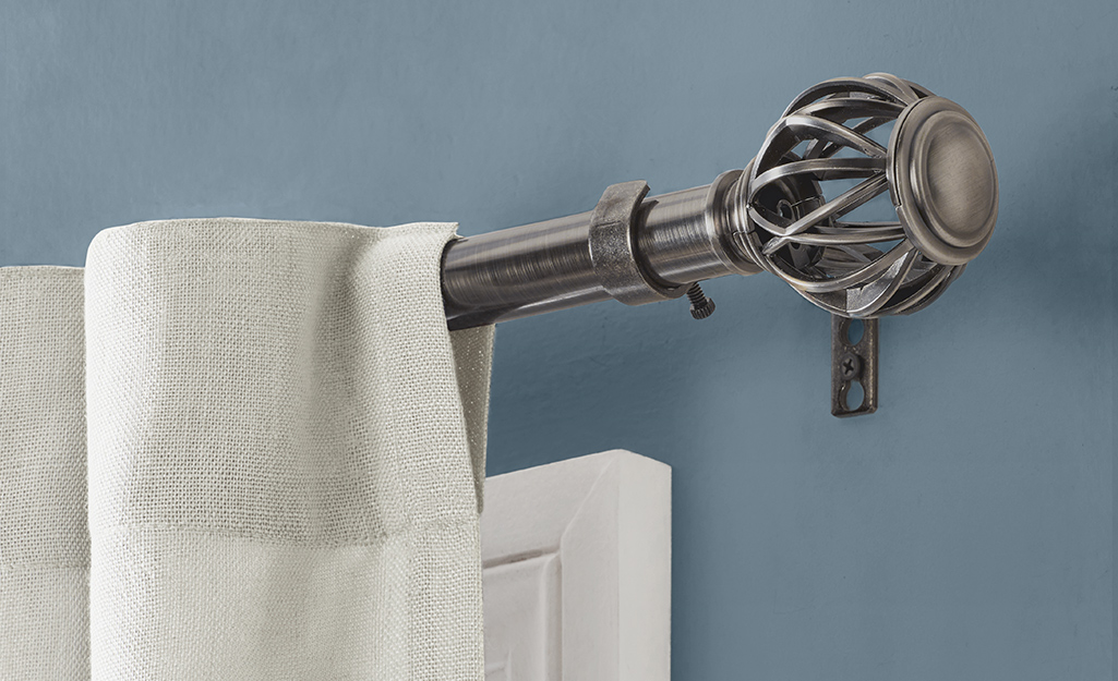 A single curtain rod featuring a decorative pewter finial.