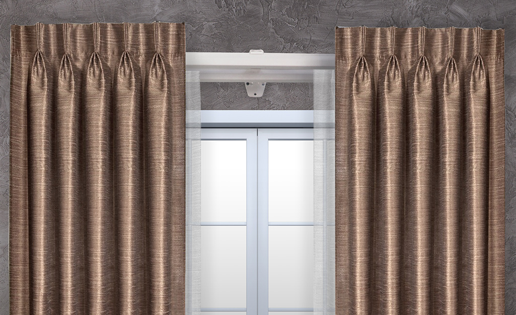 Formal draperies hanging on a traverse curtain rod.