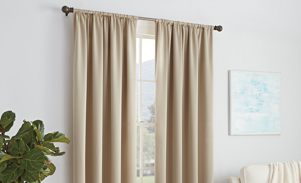 Beige curtains hanging in a room.