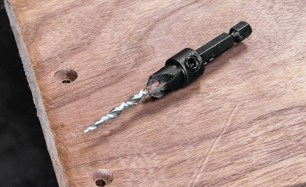 A countersink drill bit on a piece of wood.