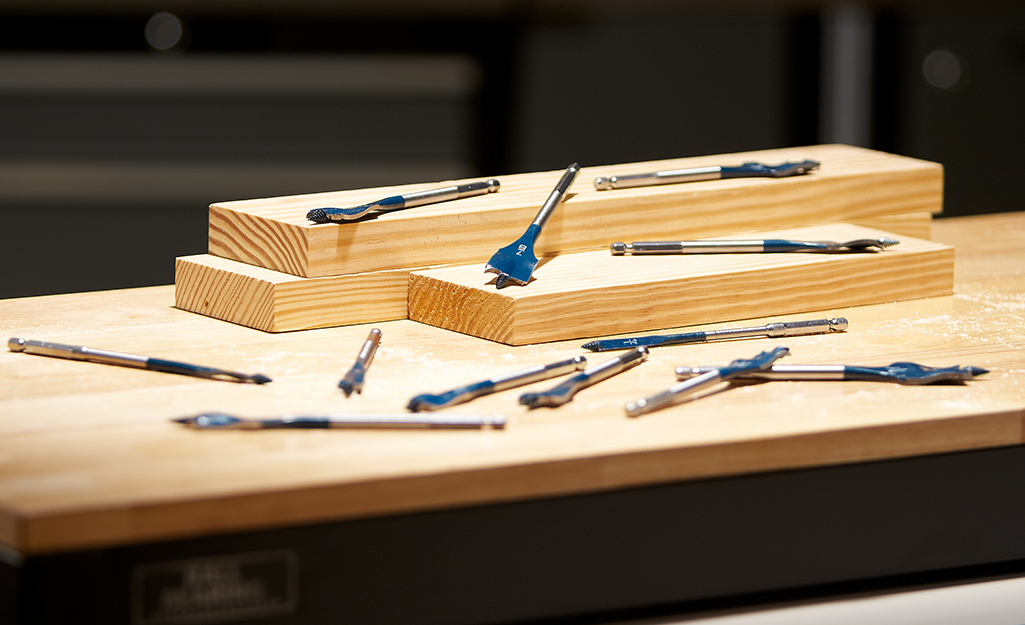 Different types of drill bits on a piece of wood. Different types of drill bits on a piece of wood.