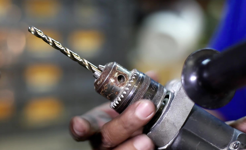 Someone holding a twist drill bit. Someone holding a twist drill bit.