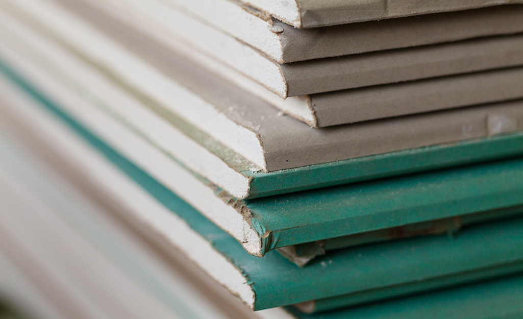Stacks of drywall sheets in different shades.