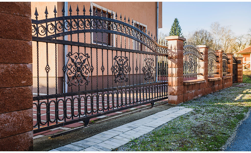 A wrought iron fence featuring scrolls and spear points..