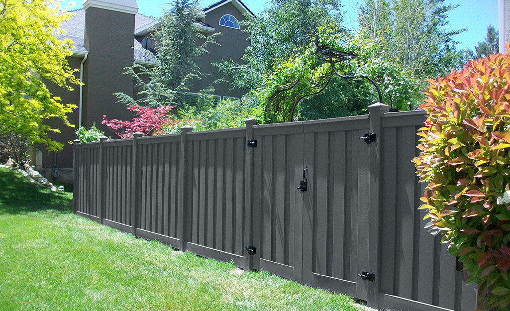 A gray composite privacy fence surrounding a property.