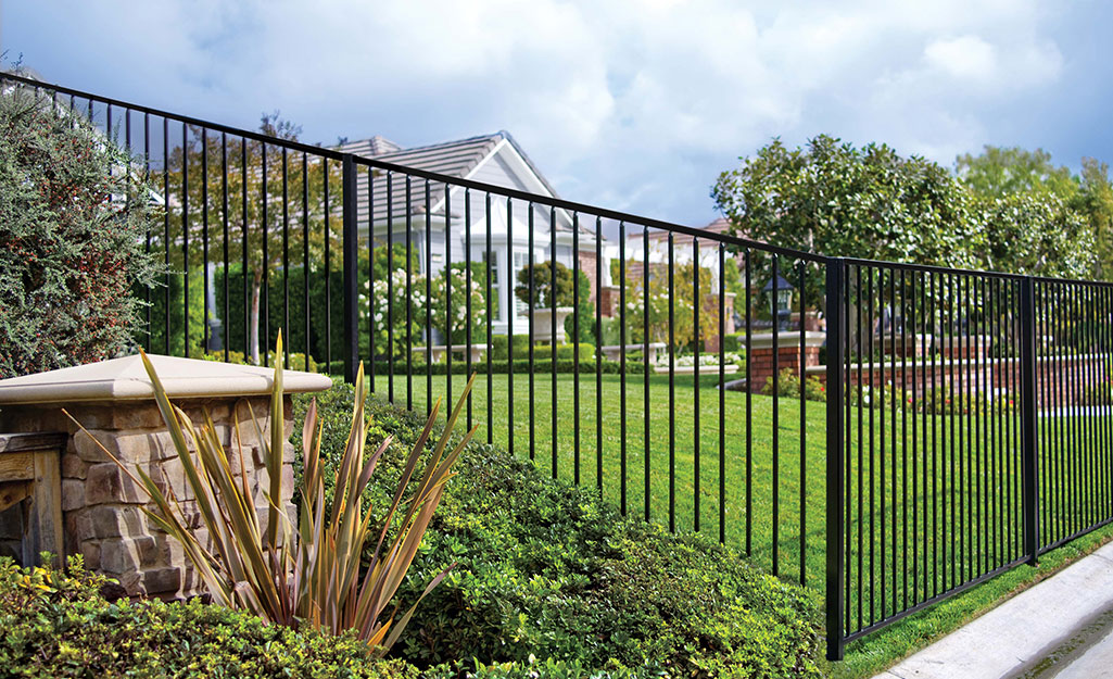 Black metal fence surrounding a large property.