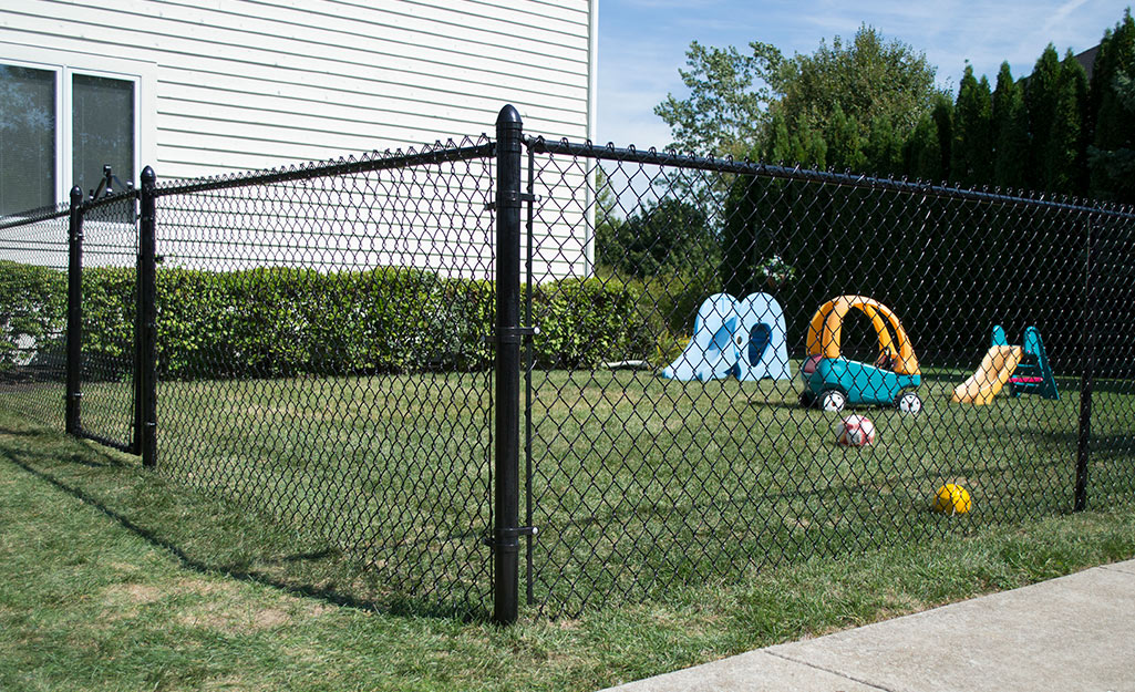 A black chain link fence around a small yard.