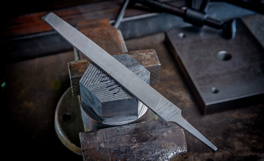 A file sits on top of a work bench.