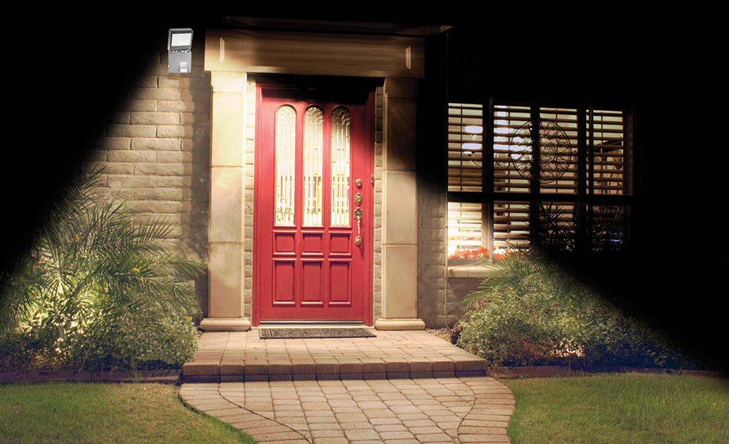 A spotlight shines on a front door and walkway. A spotlight shines on a front door and walkway.