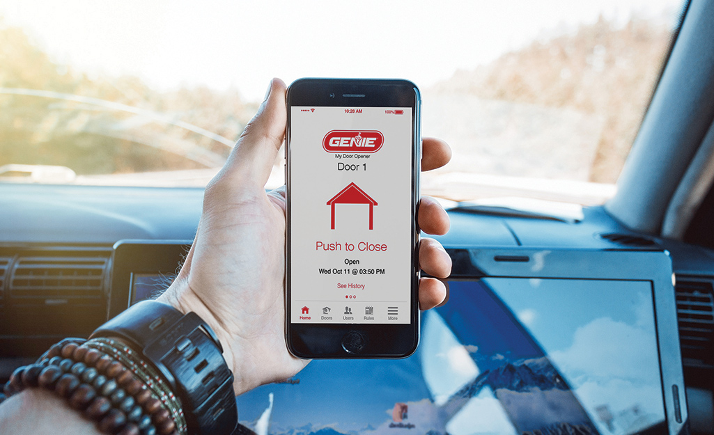 A person uses a mobile device to activate a smart garage door opener.