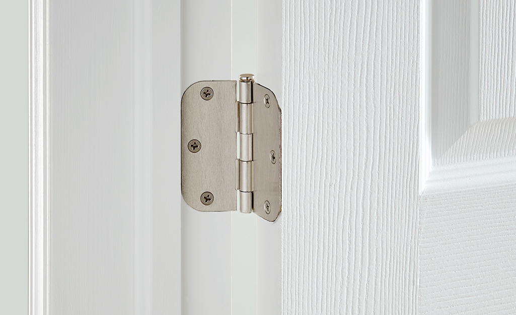 A butt hinge attached to a door and frame.