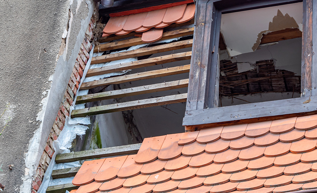 A roof and window with hurricane damage.