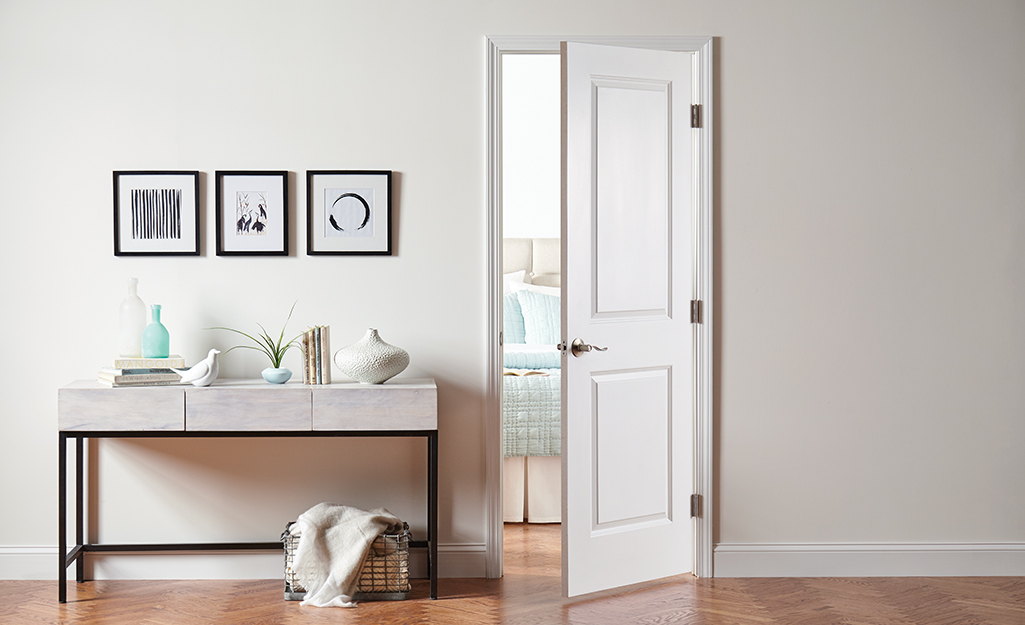 An open interior door installed beside a console table.