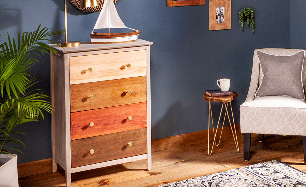 A wood dresser with drawers stained in various finishes.