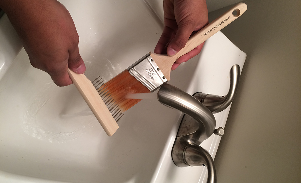 A person cleaning a paint brush.