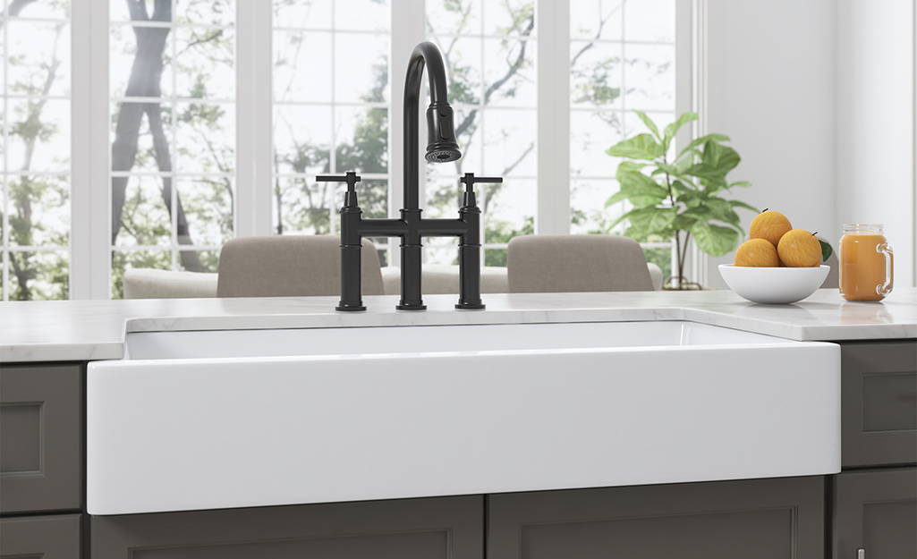 A single bowl kitchen sink with a black faucet.