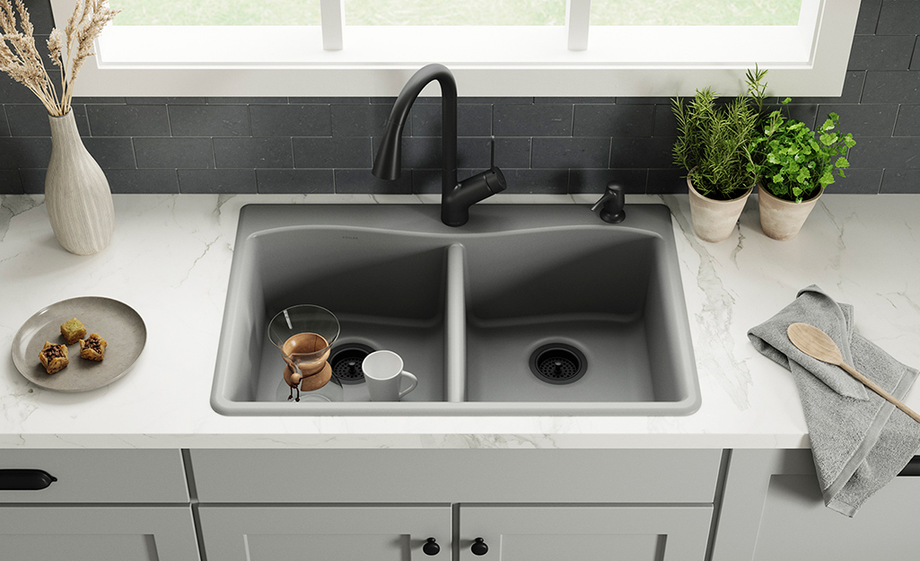 A double kitchen sink installed in a solid countertop.