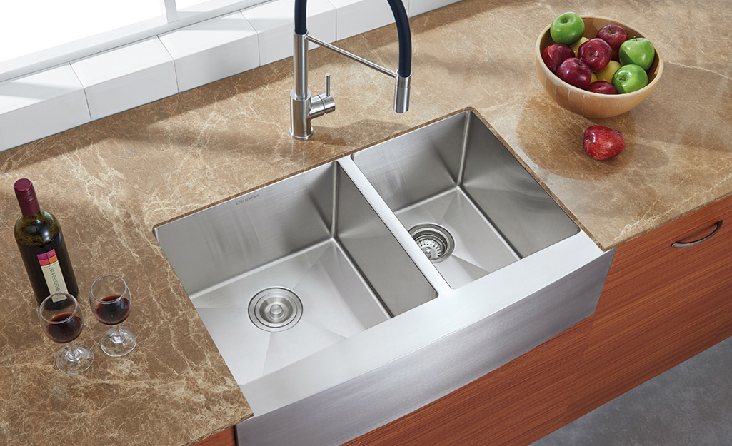 An apron front stainless steel double-basin kitchen sink.