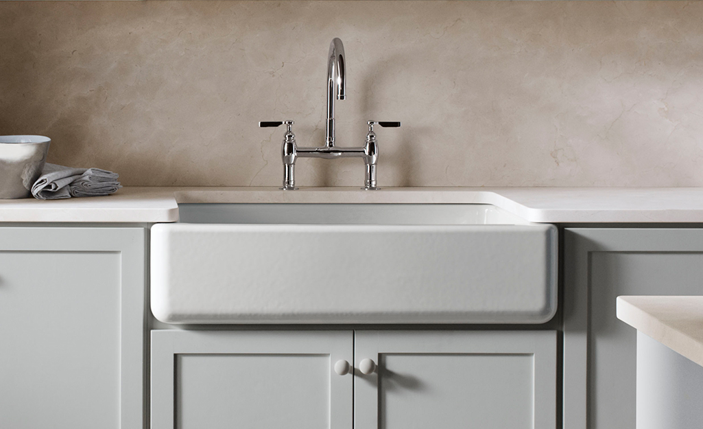 A cast iron sink in white with a silver faucet.