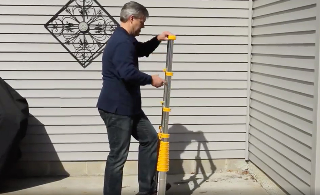 A man extending a telescoping ladder.