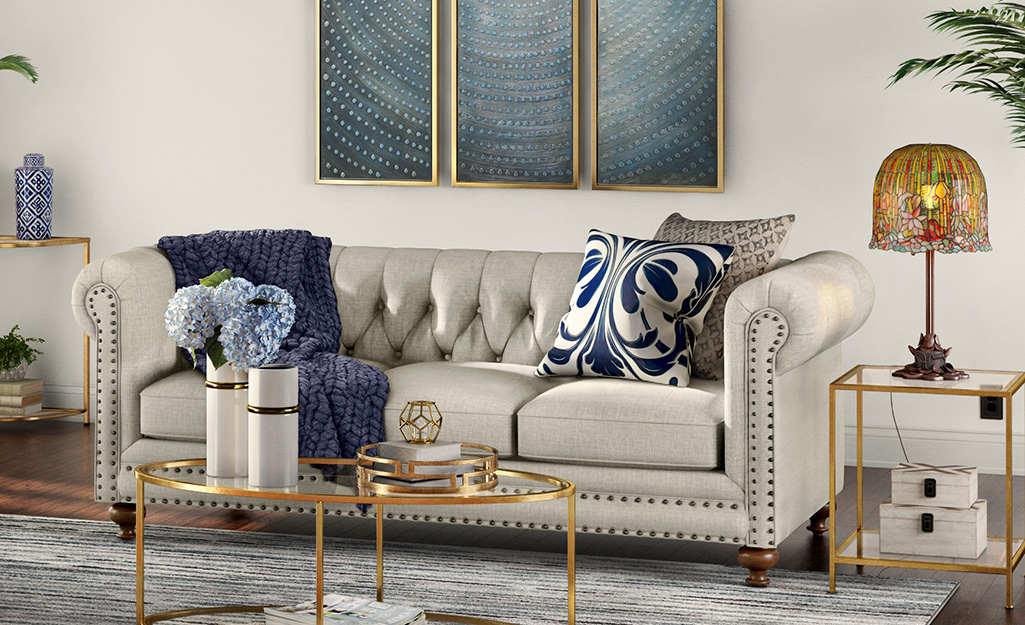 A Tiffany-style dome lampshade placed on a brass end table.