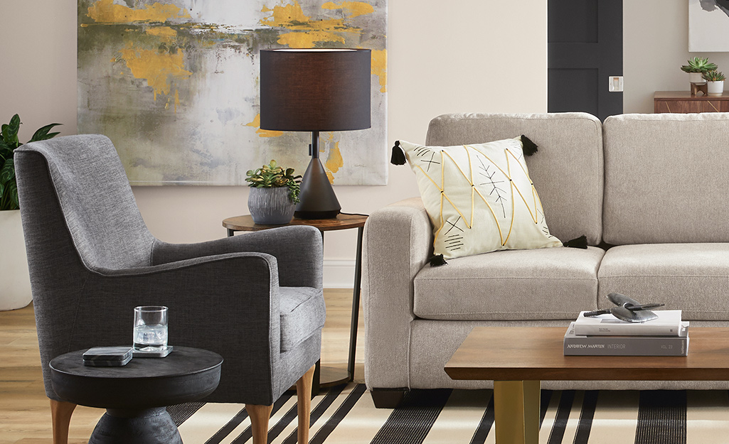 An upholstered armchair placed next to a lamp with a fabric shade.