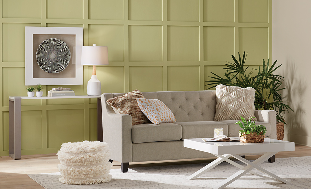 A green living room wall with moulding detail.