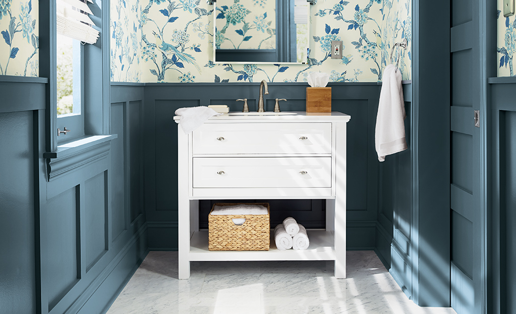 A bathroom with blue painted walls that feature moulding.