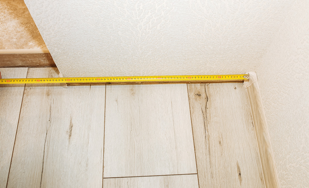 A tape measure being used to measure for moulding.