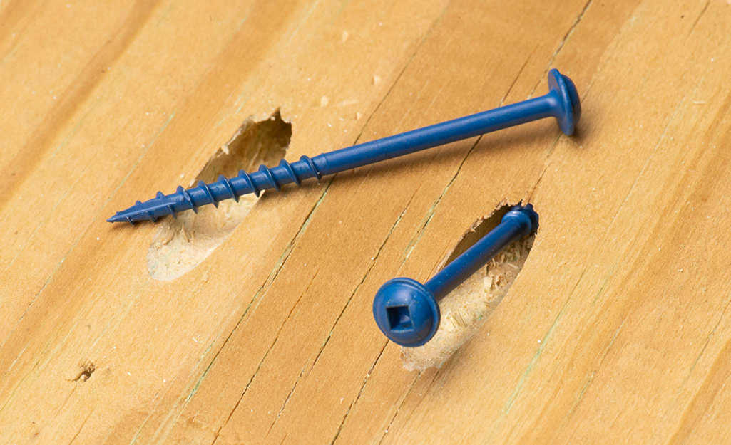 A ceramic screw drilled into a piece of wood.