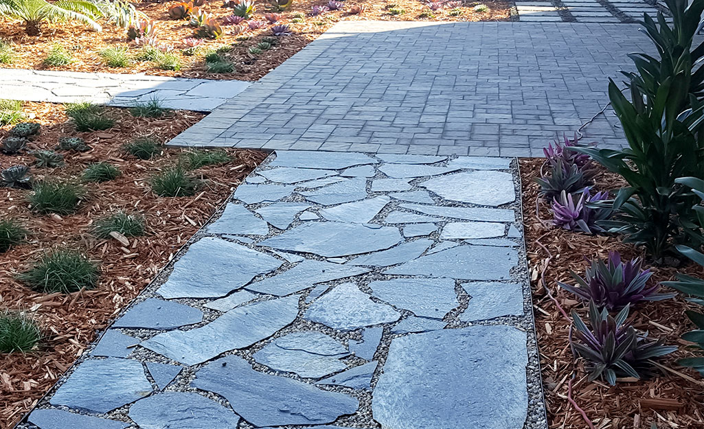 A walkway and stoop made of natural stone pavers.