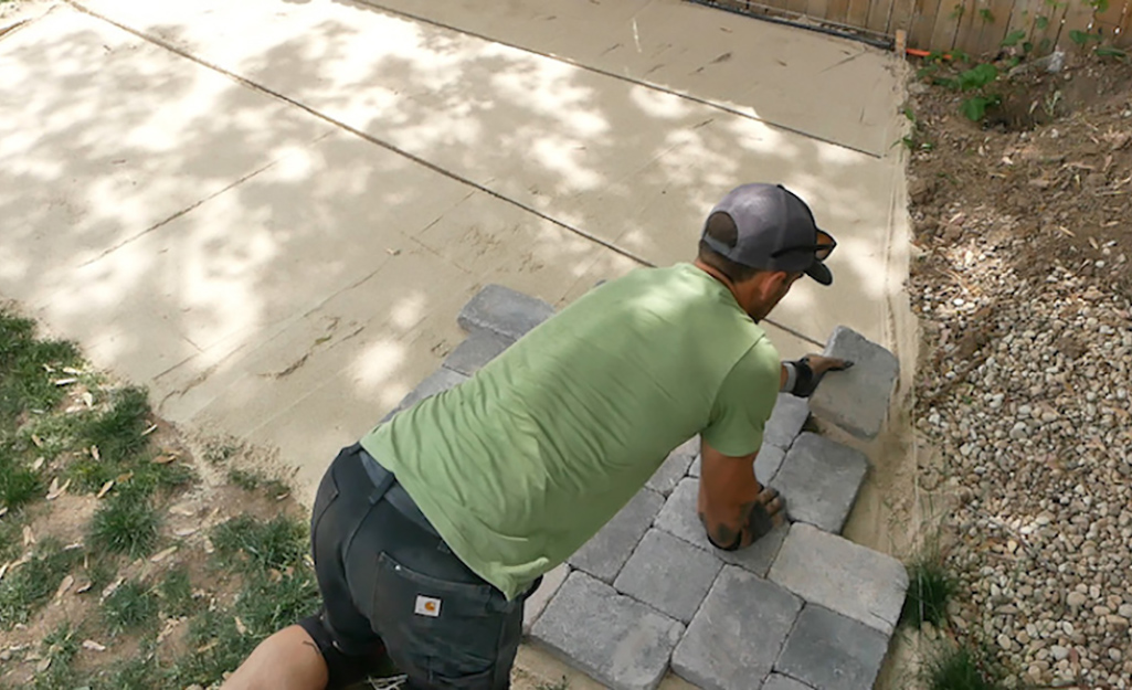 A person installing pavers outdoors.