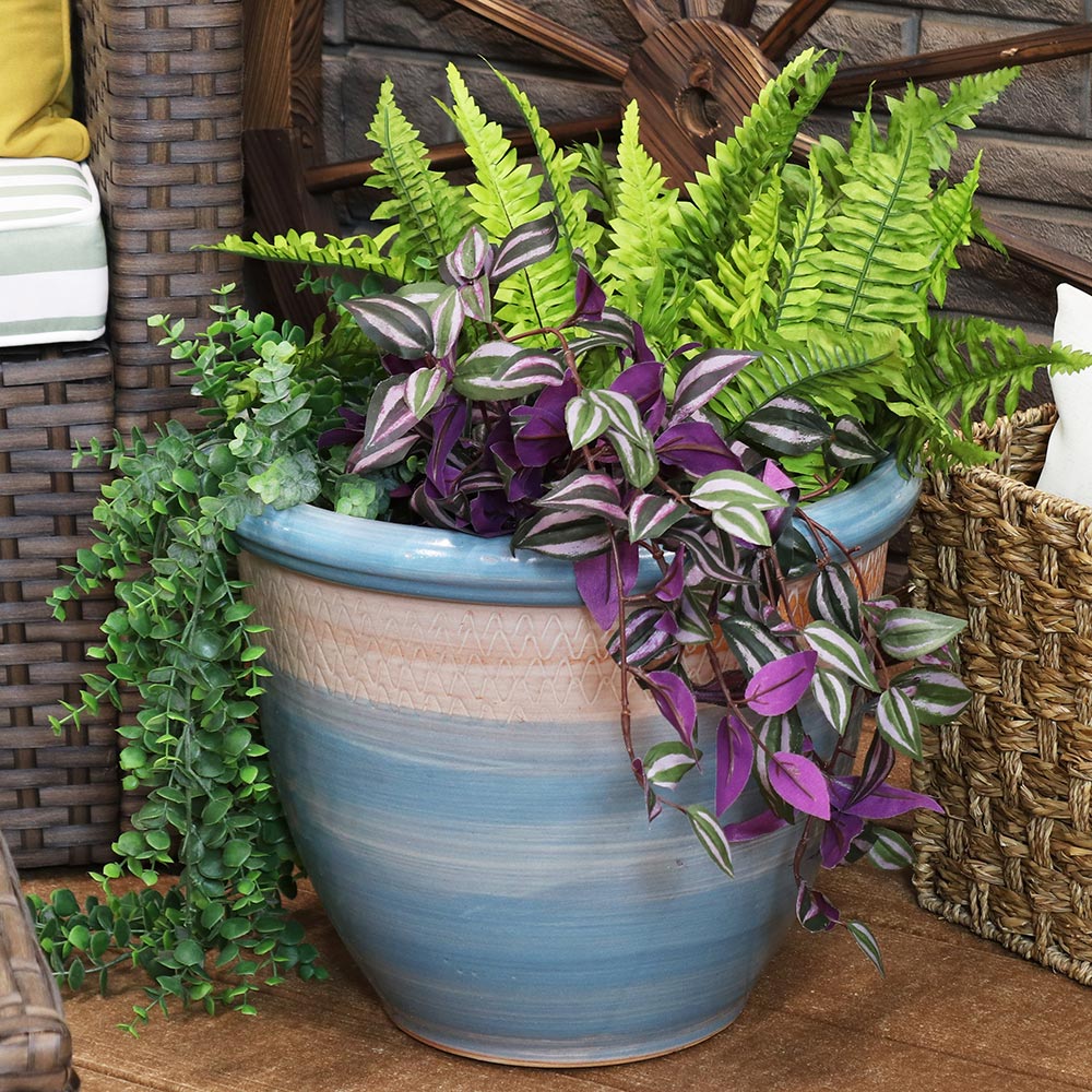 Different types of plants grow in a blue and white planter.