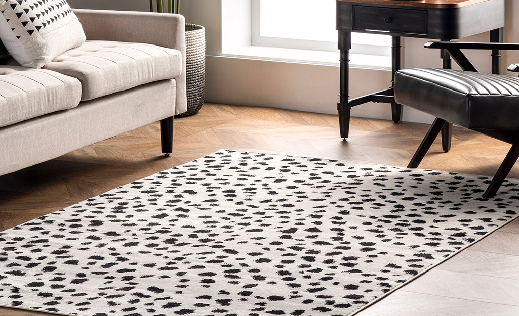 An animal print rug lays in front of a couch in a living room.