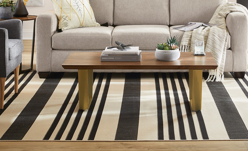 A striped rug lays under a wooden coffee table in a living room.