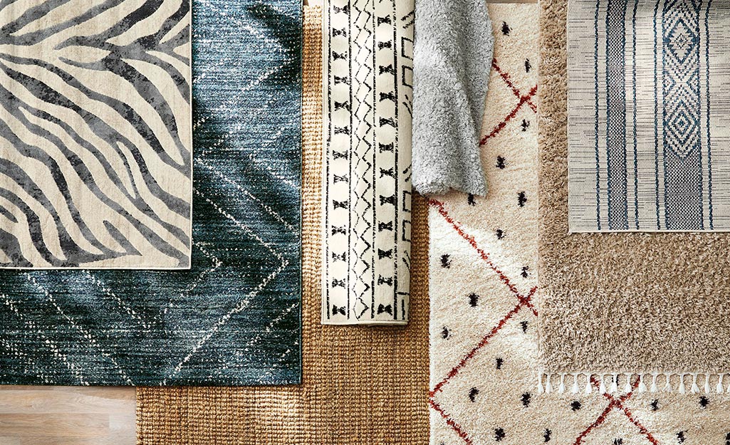 A variety of area rugs are layered on top of each other.