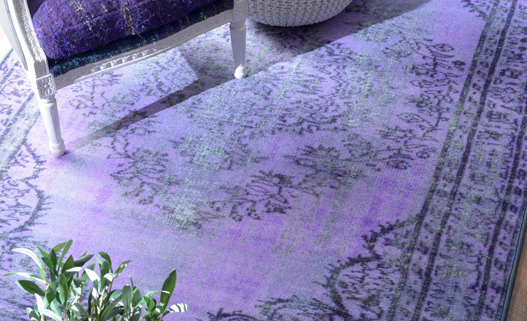 A lavender overdyed rug under a chair.